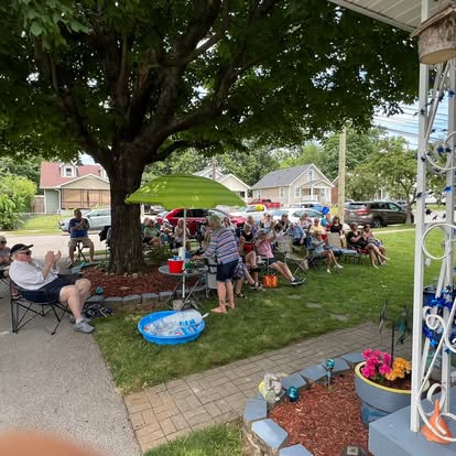 A crowd gathered for an outdoor porch concert.